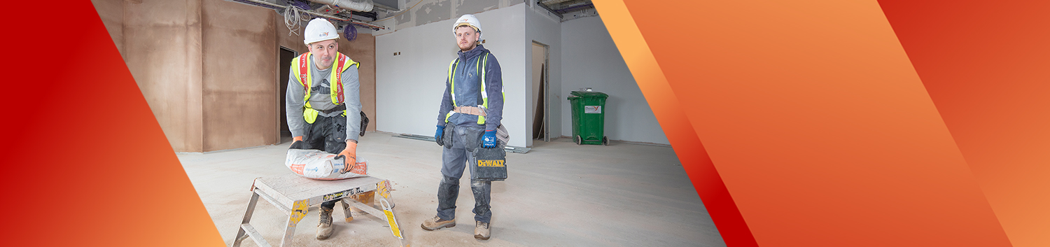 Two plasterers in industrial room